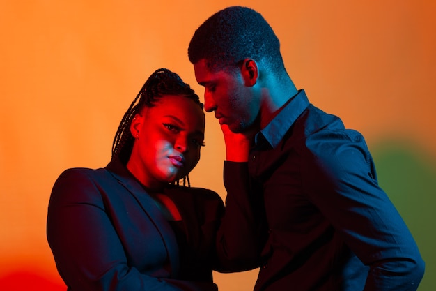 Donkere neon portret van jonge Afro-Amerikaanse man en vrouw. Rood en blauw licht.