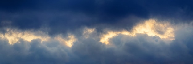 Donkere onweerswolken verlicht door het heldere avondzonpanorama