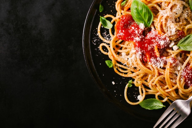 Donkere plaat met Italiaanse spaghetti op donker