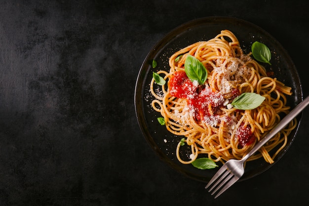 Donkere plaat met Italiaanse spaghetti op donker