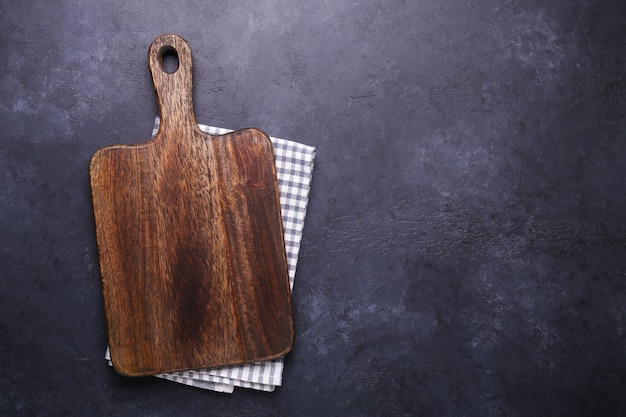 Donkere stenen tafel met snijplank en linnen servet Kopieer de ruimte