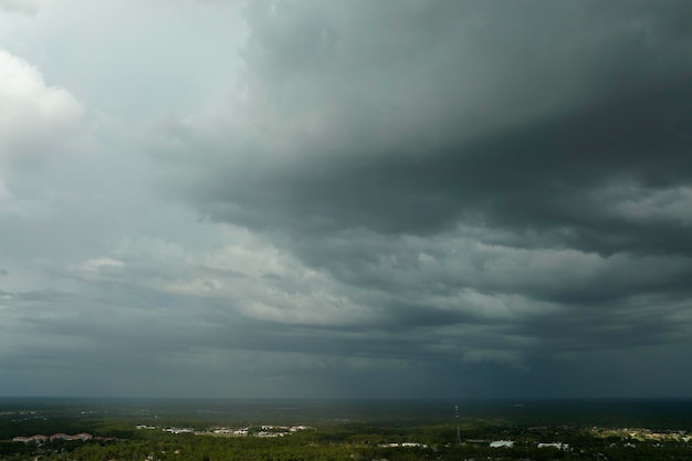 Donkere stormachtige wolken vormen zich op een sombere hemel voor zware regenval boven het stadsgebied in de voorsteden