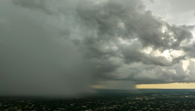 Donkere stormachtige wolken vormen zich op een sombere lucht tijdens het zware regenseizoen boven het stadsgebied in de voorsteden