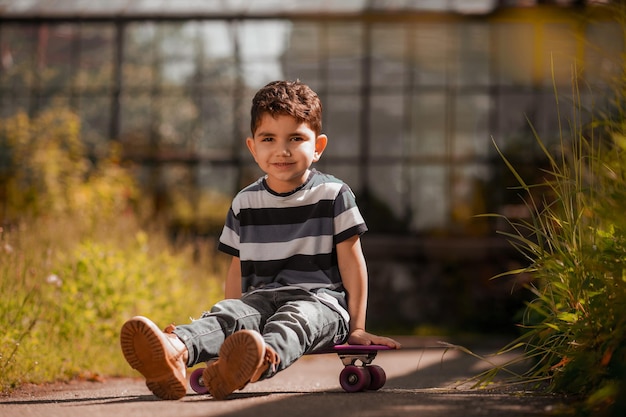 Donkerharige jongen in gestreept overhemd op een skateboard