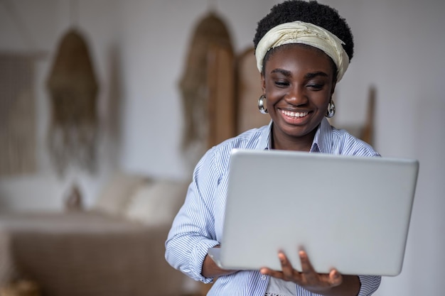 Donkerhuidige lachende vrouw met een laptop