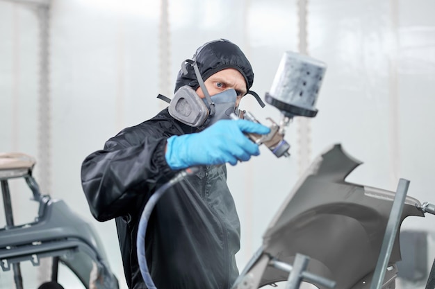 Donning a sleek black jumpsuit and a respirator an automotive wizard showcases his artistry in transforming the car's appearance