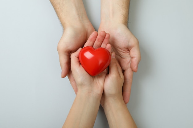 Donorconcept met handen die rood hart op witte achtergrond houden