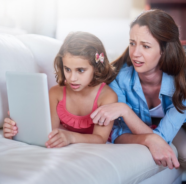 Dont forget to search safely Cropped shot of a mother and her daughter using wireless technology at home