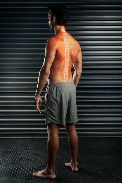 Dont succumb to back pain Studio shot of a muscular young man with his spinal column showing through cgi