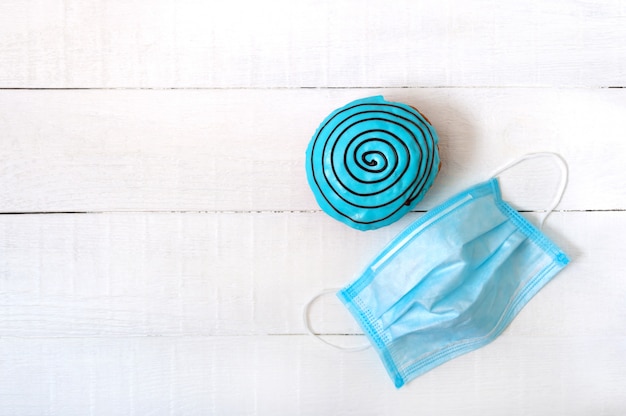 Donut in blue glaze on a white wooden background