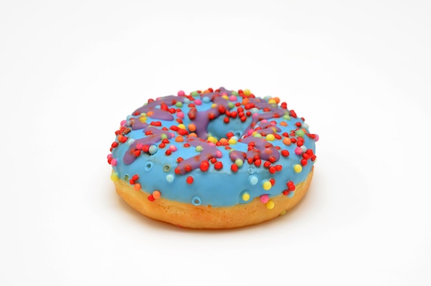 Donut met blauwe glazuur en kleurrijke hagelslag op een witte achtergrond