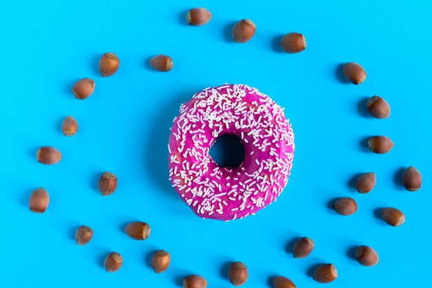 Donut met hazelnoten op blauwe achtergrond, close-up