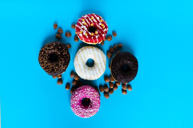 Foto donut met hazelnoten op blauwe achtergrond, close-up