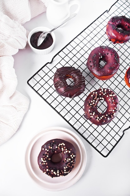 Foto donut op het bakrek geglazuurd met chocoladeroom of glazuur. ontbijt concept.