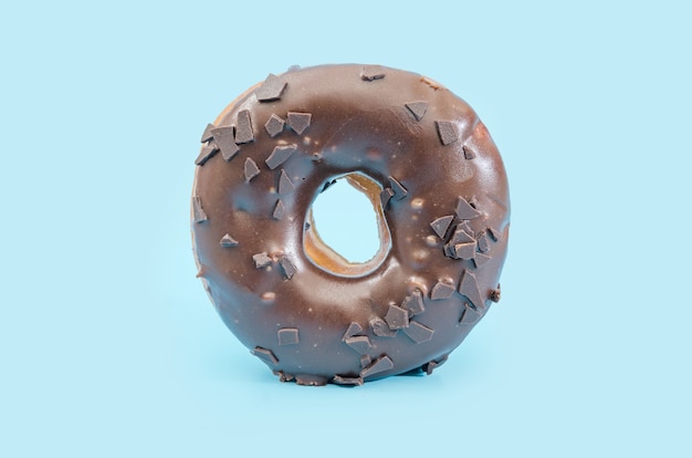 donut with black chocolate icing isolated on blue background