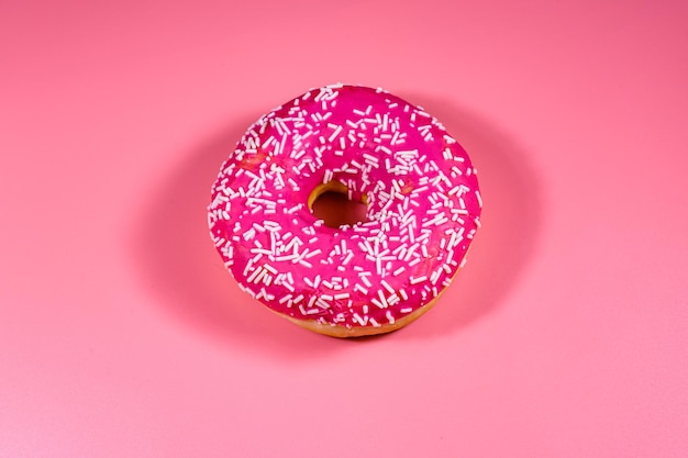 Donut with glazed top isolated on a pink background