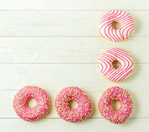 Donut on a wooden table. Photo of sweets with copyspace. Top view.