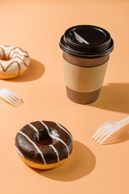 사진 베이지색 배경에 도넛과 커피 한 잔 테이크아웃 음식 개념