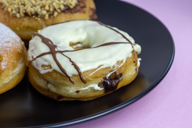 Donuts on black plate and pink background