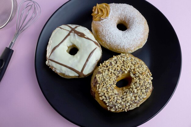 Donuts on black plate and pink background