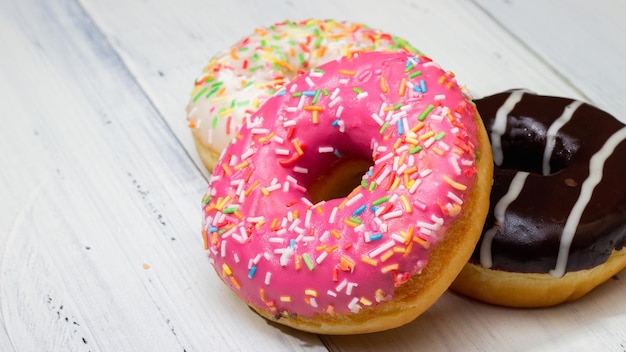 donuts of different colors on a white table