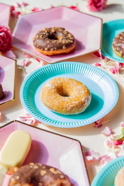 Donuts en ijs op borden met dianthusblaadjes