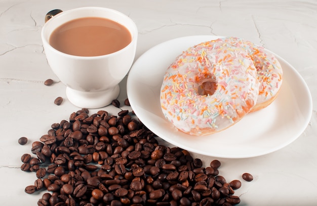 Donuts en koffie met natuurlijke melk op een lichte ondergrond. Junk