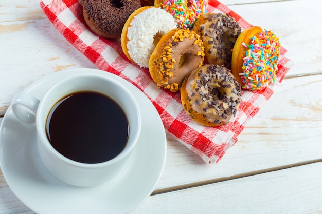 Donuts en koffie op een witte houten ondergrond,