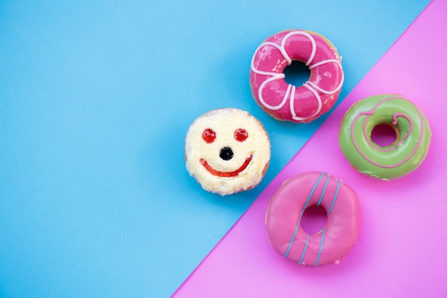 Donuts geglazuurd met hagelslag op roze blauw en pastelkleur