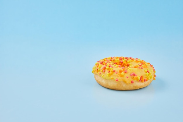 Donuts glazed with sprinkles on pastel blue background Sweet doughnuts on blue paper