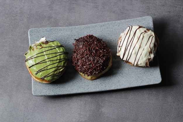 Photo donuts on an iron tray with a variety of delicious toppings