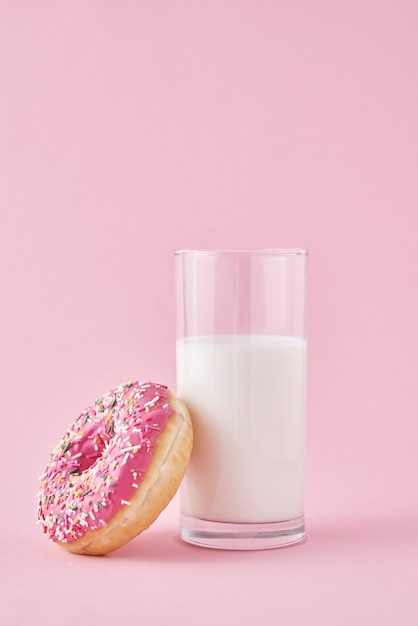 Donuts met glas melk op roze oppervlak