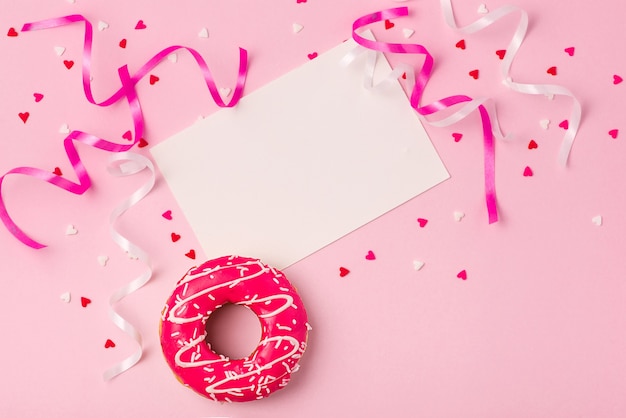 Donuts met slagroom op pastel roze achtergrond met copyspace. Zoete donuts.
