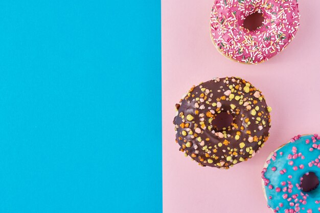 Donuts op pastelroze en blauw. Minimalisme creatieve voedselsamenstelling. Plat lag stijl