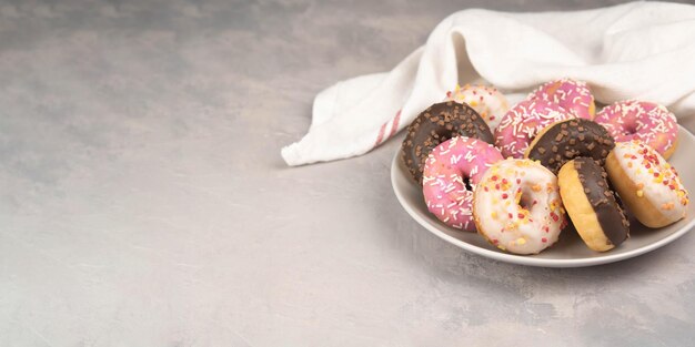 Donuts on plate on light gray background