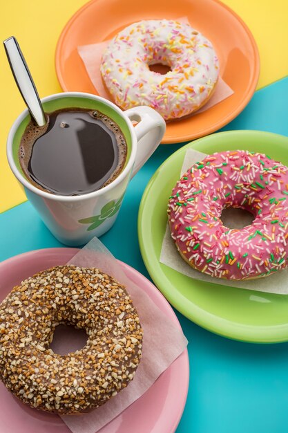 Donuts on plates and a cup of coffee