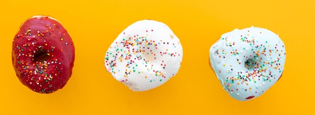 Donuts set geïsoleerd op een gele achtergrond Leuke kleurrijke en glanzende donuts met glazuur en poeder