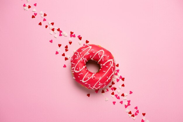 Donuts with icing on pastel pink background with copyspace. Sweet donuts.