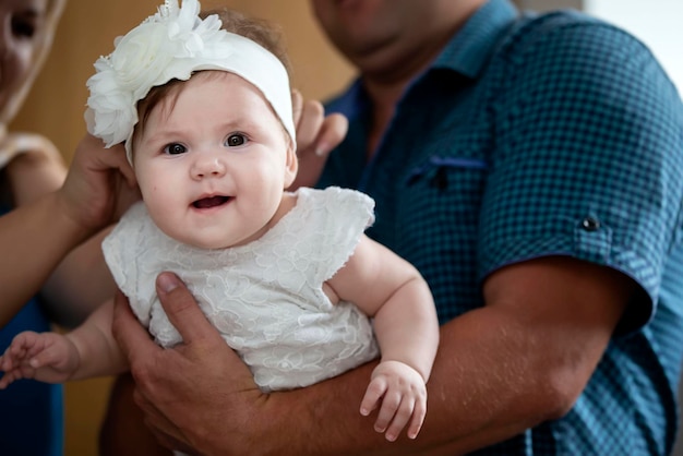 Doop van het kind Een schattige baby in de armen van haar vader