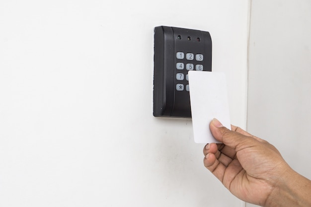 Controllo accessi alla porta - giovane donna che tiene una chiave magnetica per bloccare e sbloccare la porta., keycard