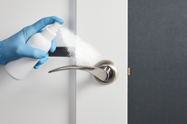Дверная ручка для дезинфекции белых дверей и спреи для предотвращения вирусной инфекции во время COVID-19.