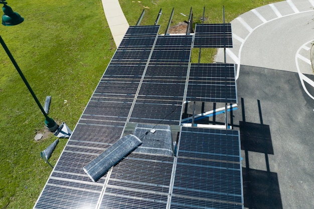 Door orkaanwind beschadigde fotovoltaïsche zonnepanelen gemonteerd op het dak van het parkeergebied voor het produceren van groene ecologische elektriciteit Gevolg van een natuurramp in Florida USA