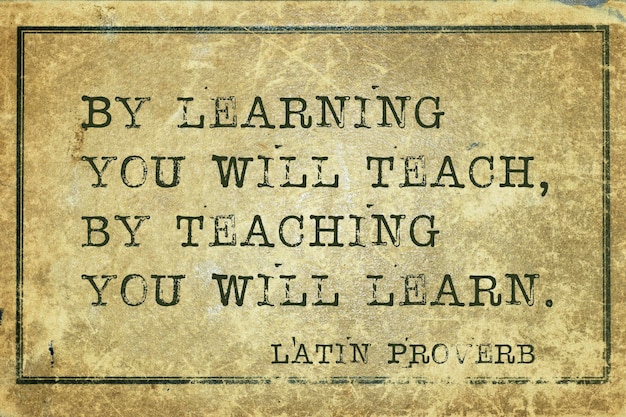 Door te leren, leer je door te onderwijzen, leer je het oude Latijnse spreekwoord gedrukt op grunge vintage kartonxA