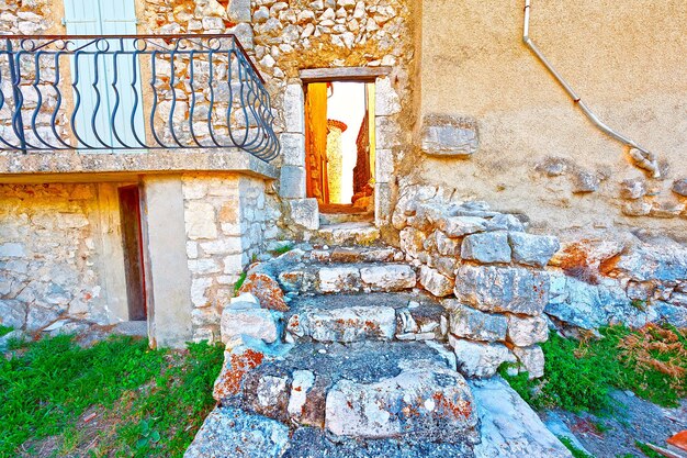 Door in the wall of the old french house leading to the deserted street