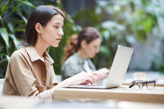 Doordachte dame die met laptop werkt