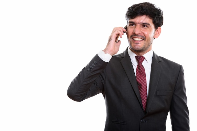 Doordachte jonge gelukkige Perzische zakenman lachend tijdens het gesprek aan de telefoon