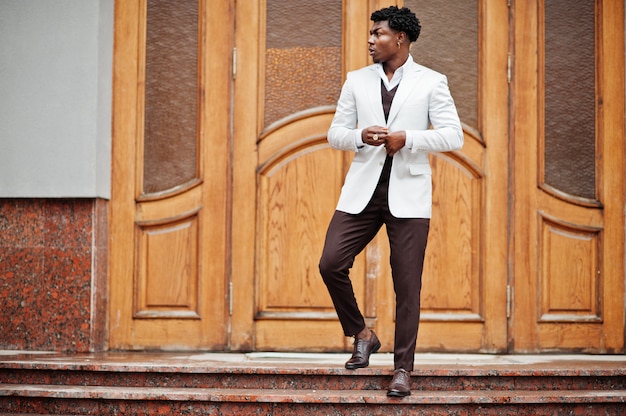 Doordachte jonge knappe afro-amerikaanse man in formalwear. zwarte stijlvolle model man in witte jas.