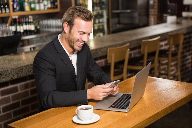 Doordachte man met laptop en smartphone