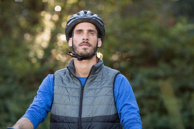 Doordachte mannelijke fietser in het bos