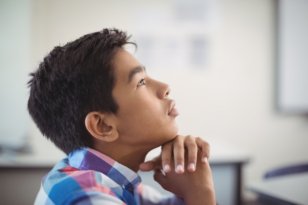 Doordachte schooljongen zit in de klas